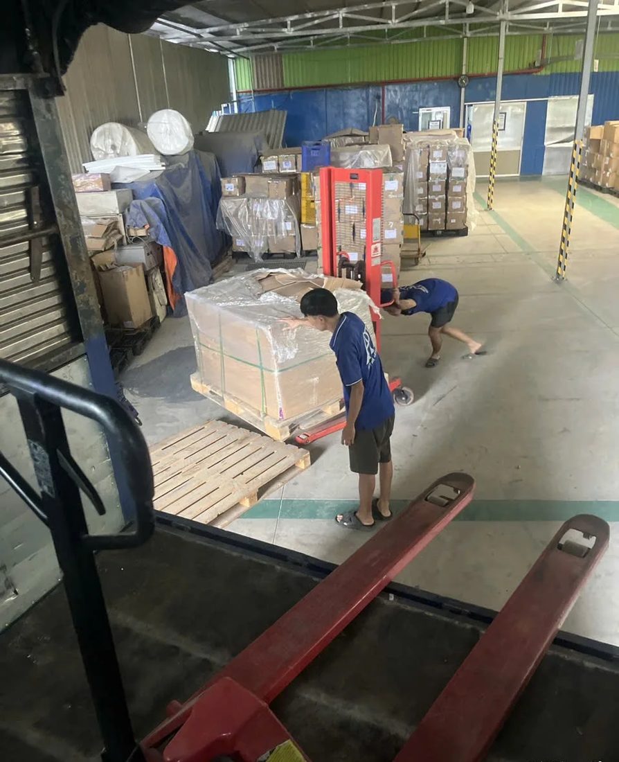 Xe nâng tay di chuyển kiện hàng trong kho